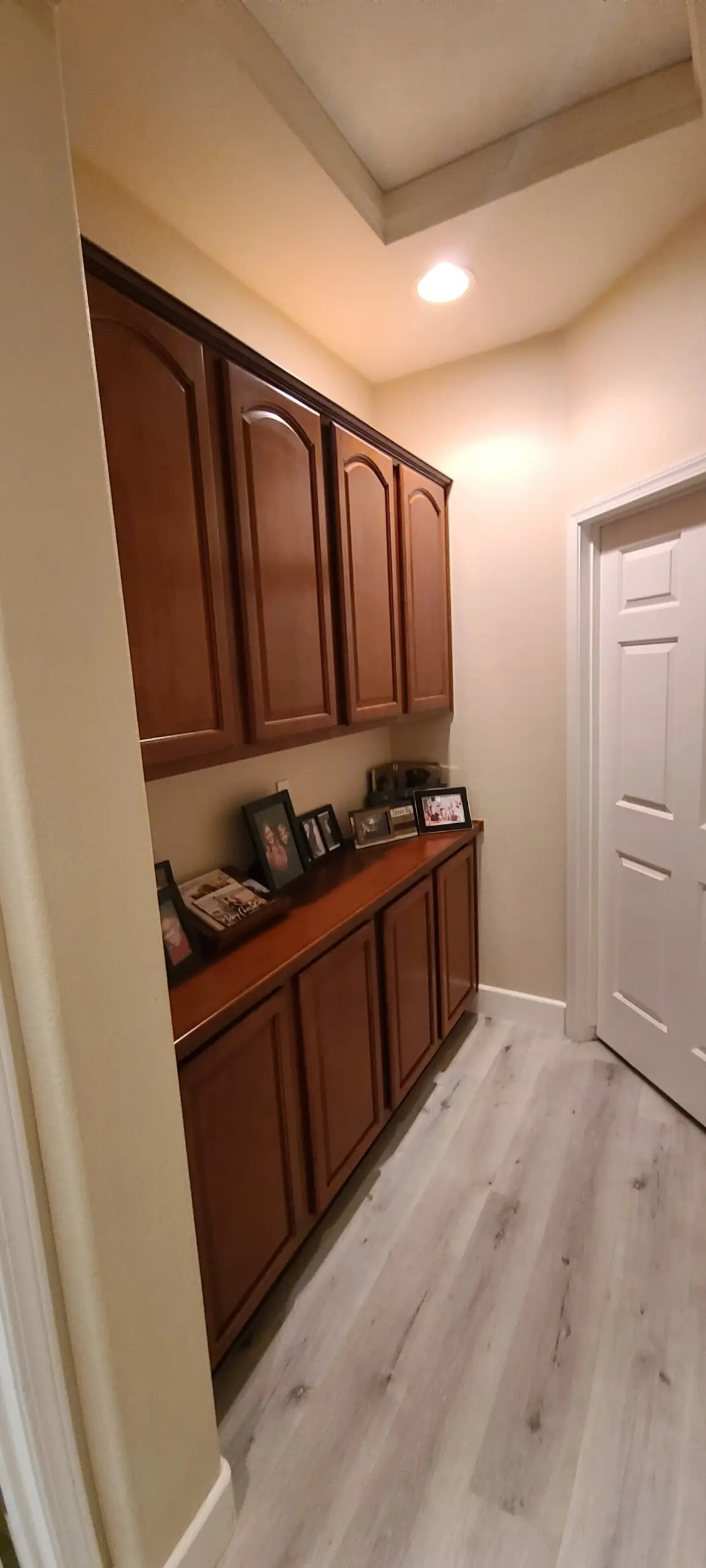 Hallway built-in with arched upper cabinets and a lower cabinet run in a rich wood stain
