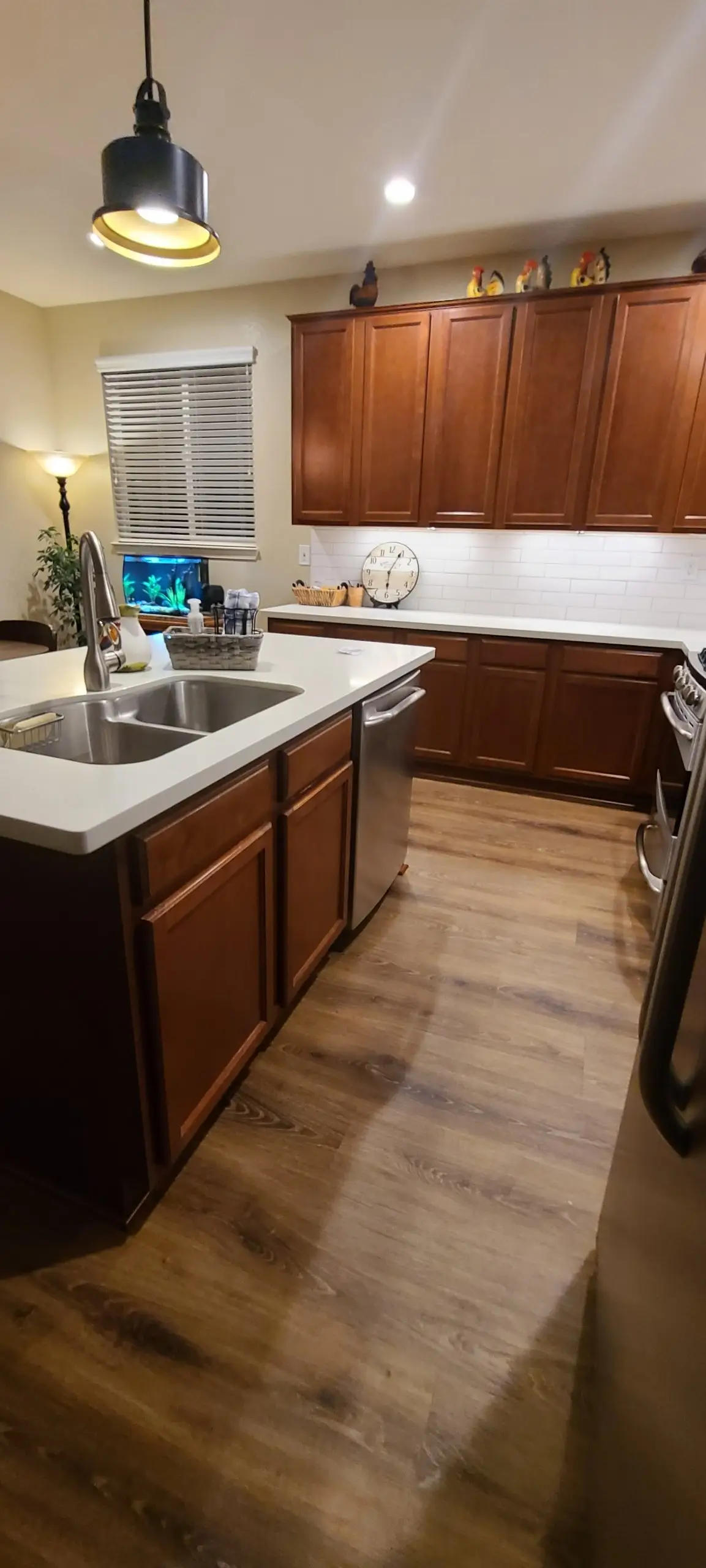 Kitchen with warm wood-stained shaker cabinets, white subway backsplash and a sink island