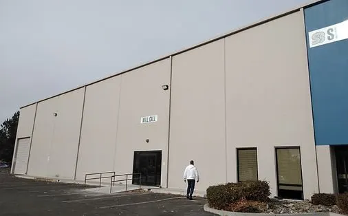Tan tilt-up concrete warehouse exterior with a will-call entrance