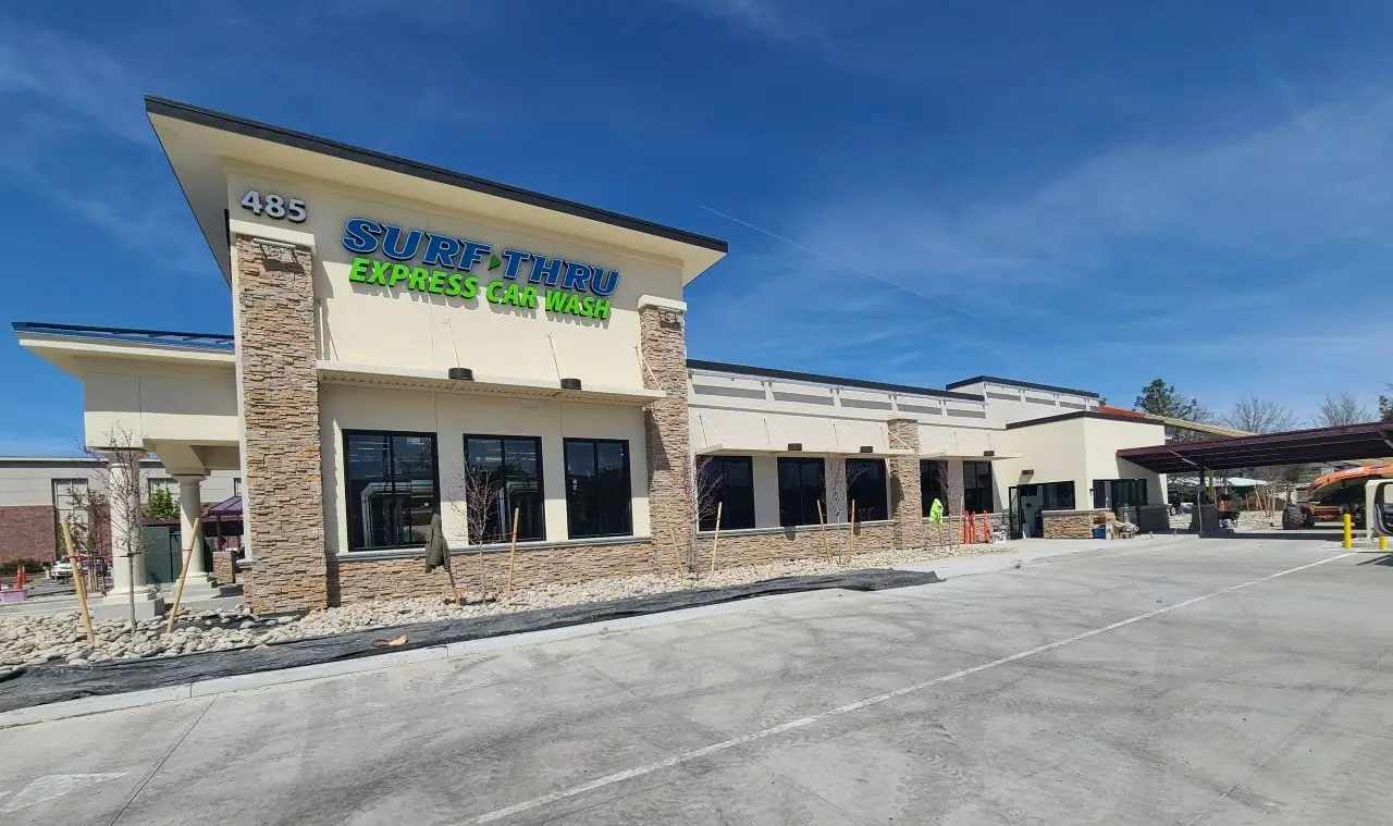 Surf Thru Express Car Wash exterior with cream stucco and stacked-stone columns