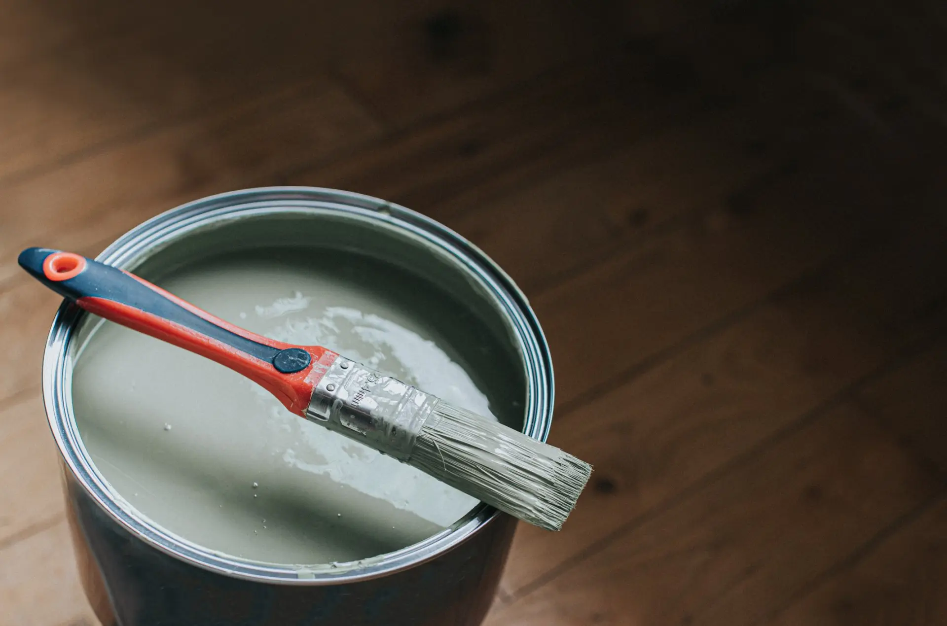 Paintbrush resting on the top of an open paint tin — Reno, NV — Parker’s Painting Inc.