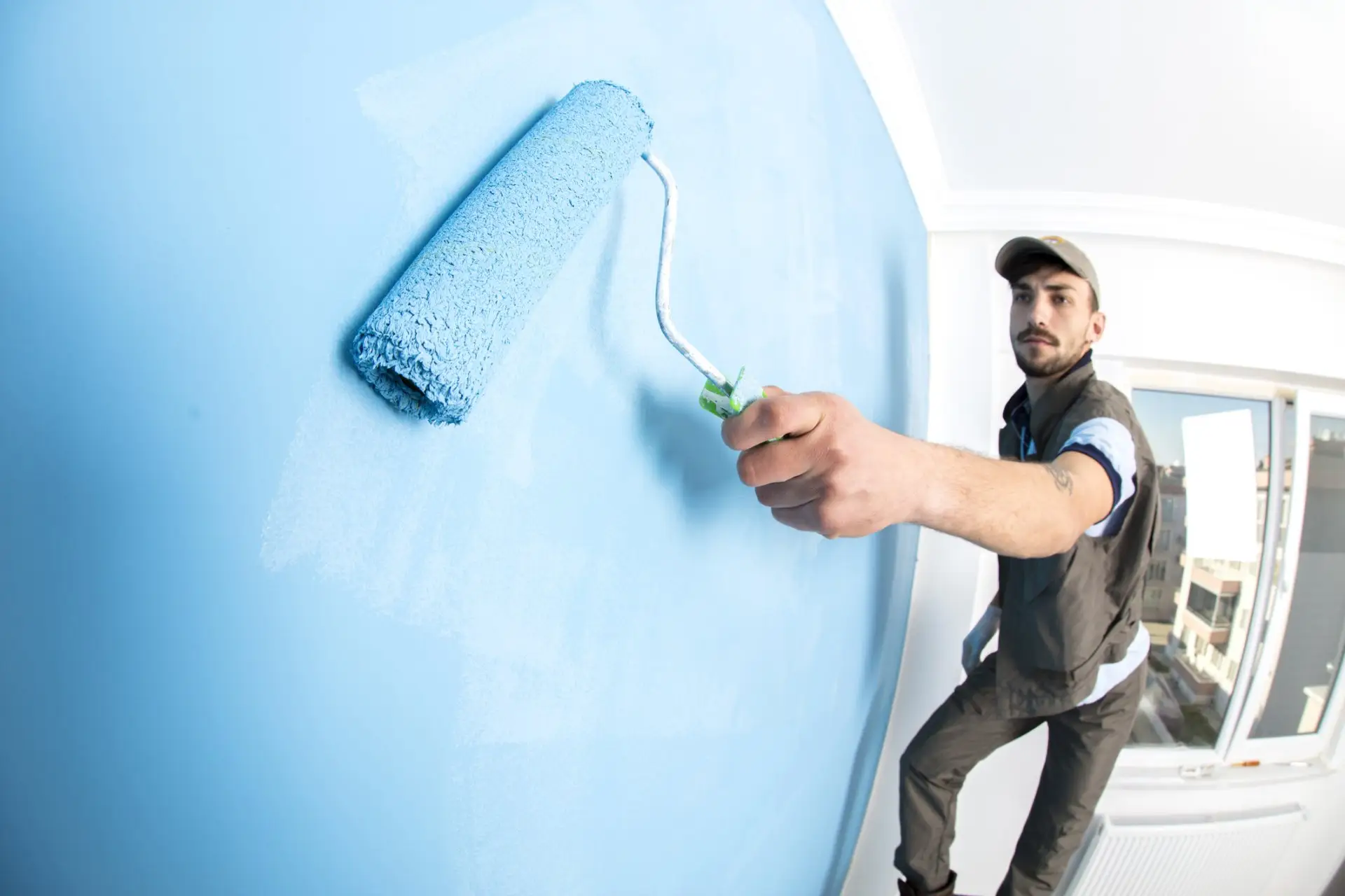 Painter rolling fresh paint onto an interior wall — Reno, NV — Parker’s Painting Inc.